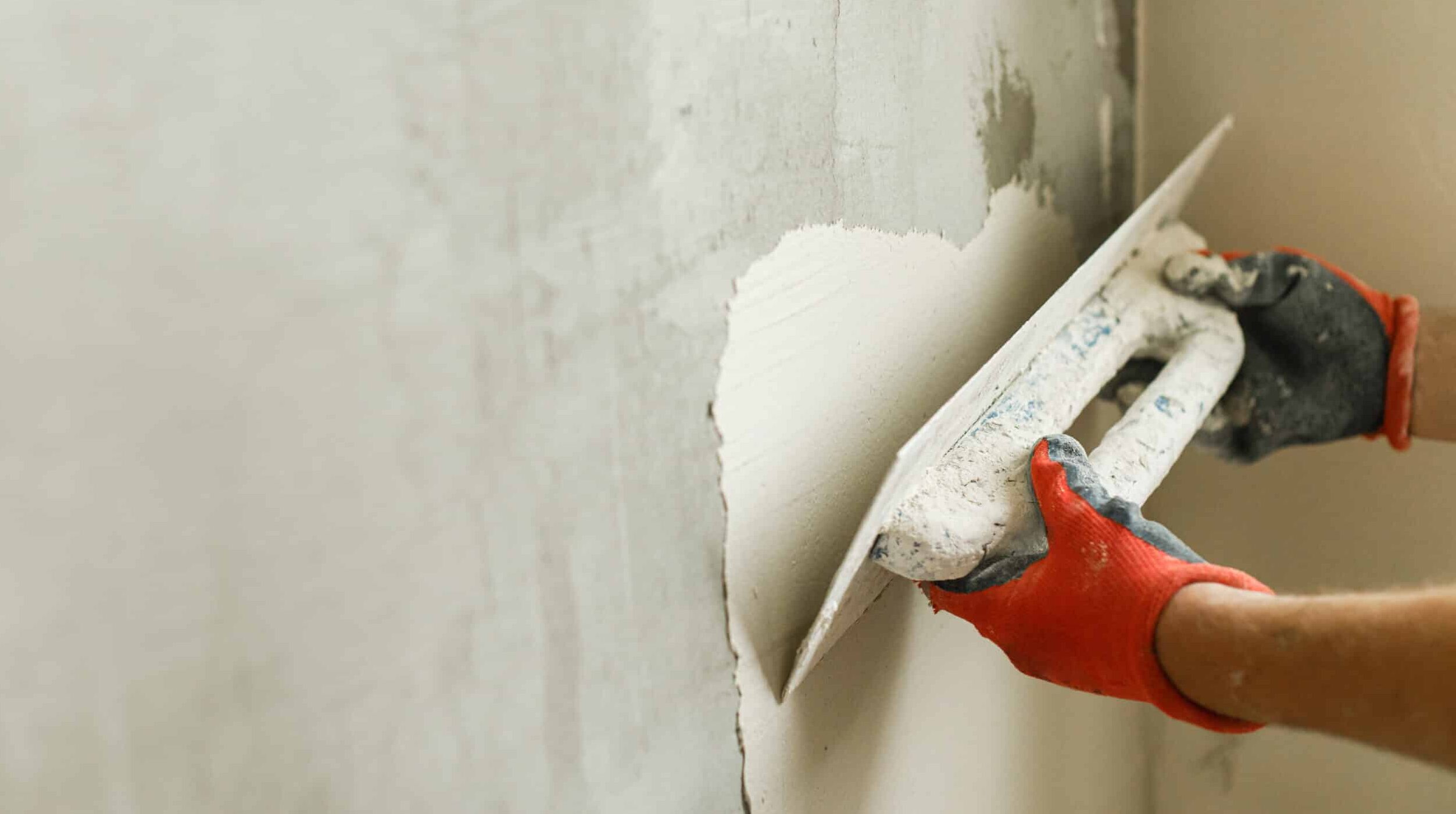 Arbeiter verputzen Wände mit Gipsputz und Spachtel